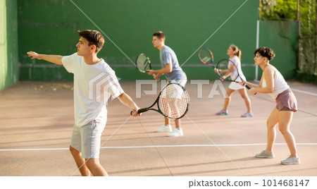 Man playing frontenis with partners at sunny day, healthy lifestyle concept 101468147