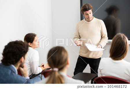 Confident male leader, trainer near interactive board talking to group of people, brainstorming, discussing ideas in auditory Confident male leader, trainer near interactive board talking to group of people, brainstorming, discussing ideas in auditory 101468172