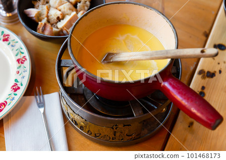 Cheese fondue with bread on a wooden table Cheese fondue with bread on a wooden table 101468173