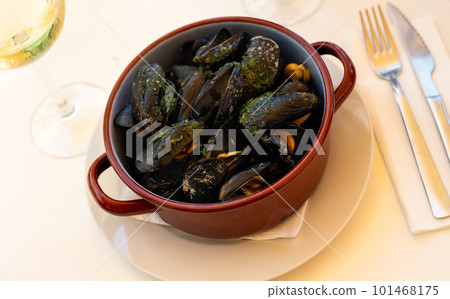 Steamed mussels with garlic butter sauce in clay pan Steamed mussels with garlic butter sauce in clay pan 101468175