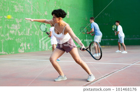 Woman pelota player hitting ball with racket 101468176