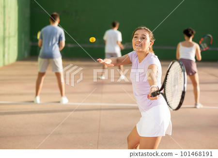 Woman playing frontenis with partners at sunny day, healthy lifestyle concept 101468191