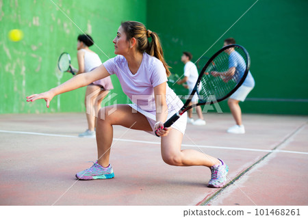 Expressive resolved fit girl playing frontenis ball friendly match on court Expressive resolved fit girl playing frontenis ball friendly match on court 101468261