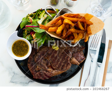 Veal entrecote with fried potatoes, fresh greens and caper sauce Veal entrecote with fried potatoes, fresh greens and caper sauce 101468267