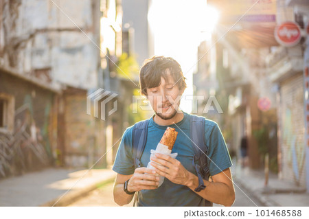 Man eating street food in Istanbul. Balik ekmek - fish in a bread, traditional Turkish fast food. Istanbul, Turkey 101468588