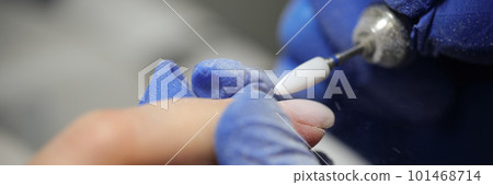 Manicurist doing hardware manicure to female client using special apparatus 101468714