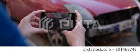 Female insurance broker making photos of car after accident on modern smartphone Female insurance broker making photos of car after accident on modern smartphone 101468742