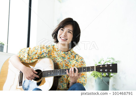 彈吉他的微笑的少婦 101468791