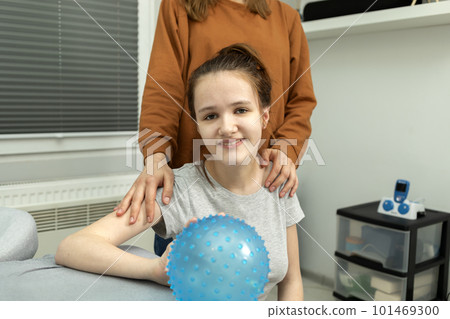 Portrait Of Pretty Smiling Teenage Girl With Cerebral Palsy With Mother Hugging Girl's Shoulders.Caring Loving Parent, Rehabilitation. Balance And Posture Maintenance, Parental Support. Horizontal 101469300