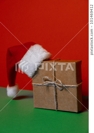 Santa hat on paper gift box present on green background. Copy space for your text. Mock up for advertisement. Holiday Christmas composition 101469412