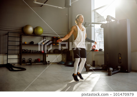 Young muscular man doing active training with jumping rope gym equipment 101470979