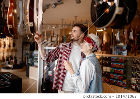 Young hipster couple searching for new electric guitar for performance 101471062