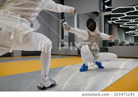 Duel of fencers during fencing match, training lesson at martial art class Duel of fencers during fencing match, training lesson at martial art class 101471293