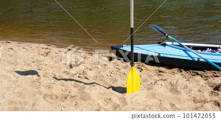 Tourist canoes with paddles stand on the river coast in summer on a water hike. Rafting on inflatable and frame double and triple kayak boats, family trip, extreme adventure in summer Tourist canoes with paddles stand on the river coast in summer on a water hike. Rafting on inflatable and frame double and triple kayak boats, family trip, extreme adventure in summer 101472055