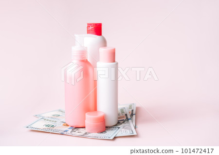 Tubes with hygiene products on dollar bills against pink background 101472417