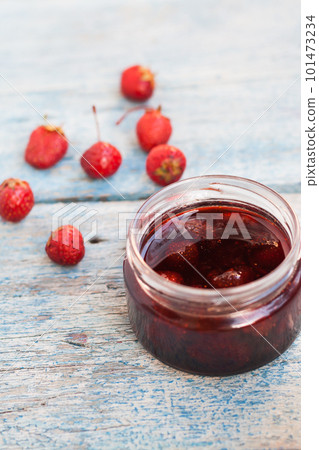 liquid strawberry jam in a jar with a spoon 101473234