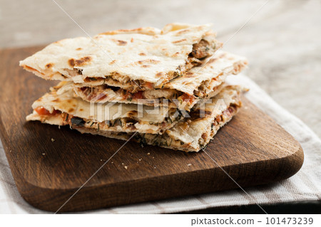 pile of quesadillas with chicken and vegetables on the rustic board 101473239