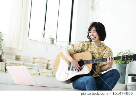 彈吉他的微笑的少婦 101474090