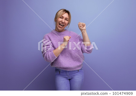 adorable energetic pleasant blond young woman with a grimace on a bright plain background adorable energetic pleasant blond young woman with a grimace on a bright plain background 101474909