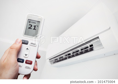 Air conditioner at home, hand with remote control Air conditioner at home, hand with remote control 101475004