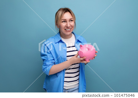close-up photo of a blonde attractive young woman in casual attire thoughtfully holding a piggy bank close-up photo of a blonde attractive young woman in casual attire thoughtfully holding a piggy bank 101475046