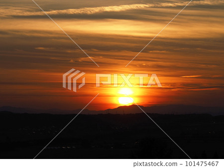 A large sunset over the mountain peak, split into two by clouds, creating a beautiful collaboration between the orange clouds and the silhouette of the mountain. A large sunset over the mountain peak, split into two by clouds, creating a beautiful collaboration between the orange clouds and the silhouette of the mountain. 101475467