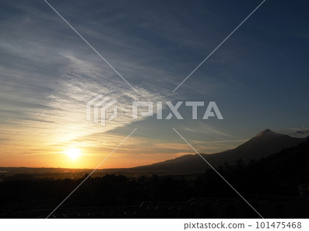 Evening view of Mount Bandai. The orange sun, white clouds like white lace curtains, and the silhouette of Mt. Bandai are impressive and beautiful. Evening view of Mount Bandai. The orange sun, white clouds like white lace curtains, and the silhouette of Mt. Bandai are impressive and beautiful. 101475468