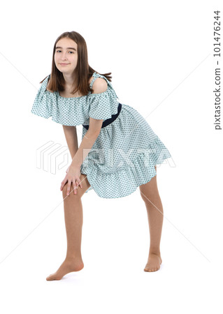 Young beautiful girl in a dress with polka dots on a white background.  101476244