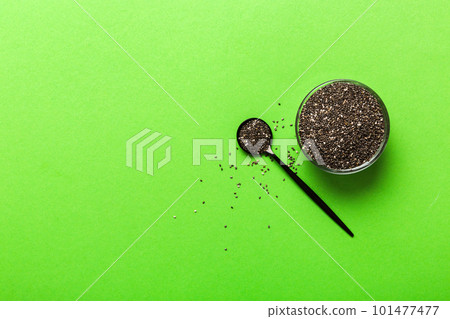 Chia seeds in bowl and spoon on colored background. Healthy Salvia hispanica in small bowl. Healthy superfood 101477477