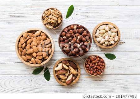 mixed nuts in wooden bowl. Mix of various nuts on colored background. pistachios, cashews, walnuts, hazelnuts, peanuts and brazil nuts mixed nuts in wooden bowl. Mix of various nuts on colored background. pistachios, cashews, walnuts, hazelnuts, peanuts and brazil nuts 101477498