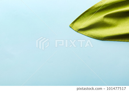 top view with green kitchen napkin isolated on table background. Folded cloth for mockup with copy space, Flat lay. Minimal style 101477517