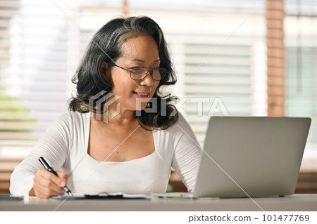 Senior woman reading online news, browsing internet on laptop at home. Retired lifestyle and technology concept Senior woman reading online news, browsing internet on laptop at home. Retired lifestyle and technology concept 101477769