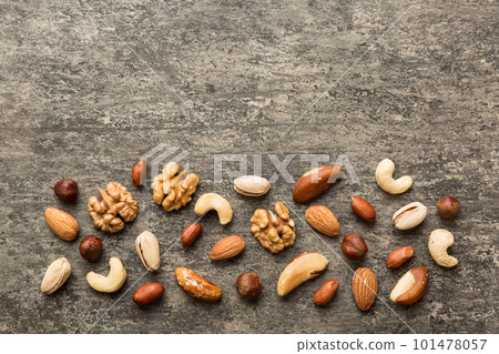 Composition of nuts , flat lay - mix hazelnuts, cashews, almonds on table background. healthy eating concepts and food background Composition of nuts , flat lay - mix hazelnuts, cashews, almonds on table background. healthy eating concepts and food background 101478057