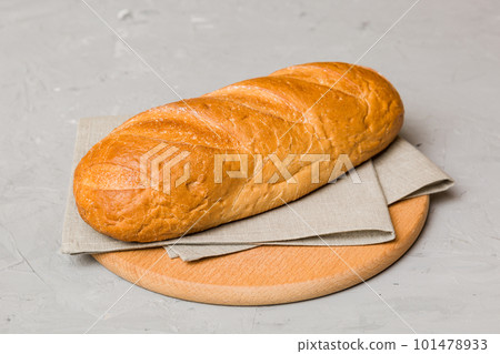 Freshly baked bread on cutting board against white wooden background. perspective view bread with copy space Freshly baked bread on cutting board against white wooden background. perspective view bread with copy space 101478933