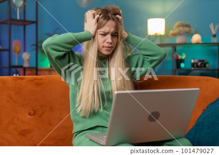 Caucasian young woman use laptop surprised by bad news, fortune loss, fail, lottery results at home 101479027