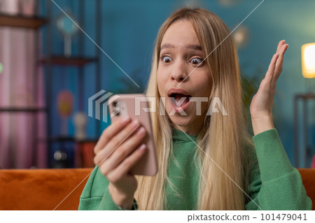 Young woman use smartphone celebrating winning lottery jackpot goal achievemen, good news, victory Young woman use smartphone celebrating winning lottery jackpot goal achievemen, good news, victory 101479041