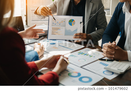 Business documents on office table with smart phone and calculator digital tablet and graph business with social network diagram and two colleagues discussing data working in the office. 101479602