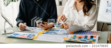 UX developer and ui designer brainstorming about mobile app interface wireframe design with customer breif and color code at office.. UX developer and ui designer brainstorming about mobile app interface wireframe design with customer breif and color code at office.. 101479695