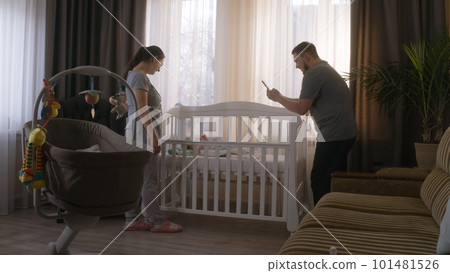 Father takes a picture or video of newborn baby 101481526