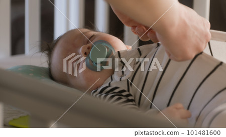Father takes off bodysuit from sleeping infant Father takes off bodysuit from sleeping infant 101481600