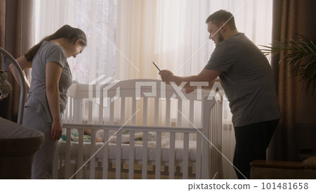 Father takes a picture or video of newborn baby 101481658
