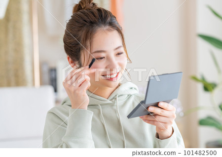 在客廳化妝的年輕女人 101482500