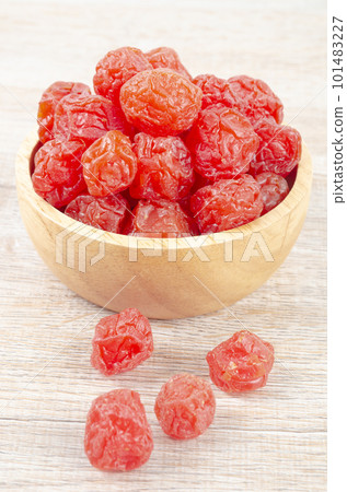The Dried red prunes fruits (Preserved fruits Chinese plum) in wooden bowl on wooden background. 101483227