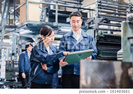 工廠員工一邊看著平板電腦一邊討論 101483681