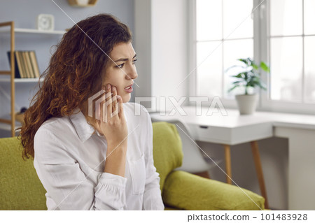 Young woman suffering from strong teeth pain or feeling discomfort after tooth extraction Young woman suffering from strong teeth pain or feeling discomfort after tooth extraction 101483928