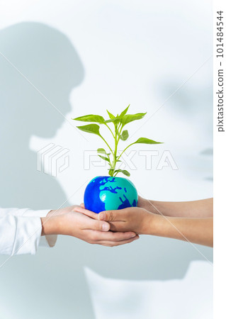 Hands handing over a flowerpot with a drawing of the earth Environmental protection image Hands handing over a flowerpot with a drawing of the earth Environmental protection image 101484544