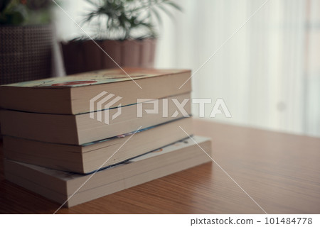 books lying on a wooden table in the living room. 101484778
