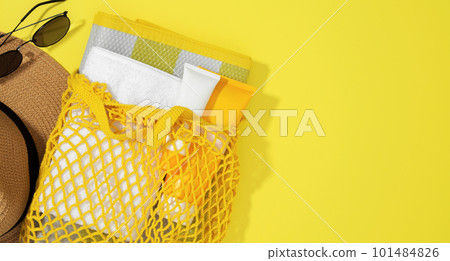 String bag with things for beach towel, sunscreens, hat and sunglasses. Safe exposure to sun. Skin Cancer Awareness Month Concept. Top view. Copy space 101484826