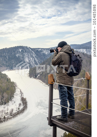 Travel photograph captures the frozen Mana River in the early springtime of Siberia's Mana Loop. The breathtaking view showcases the beauty of nature, with the river winding through the forest and Travel photograph captures the frozen Mana River in the early springtime of Siberia's Mana Loop. The breathtaking view showcases the beauty of nature, with the river winding through the forest and 101485898