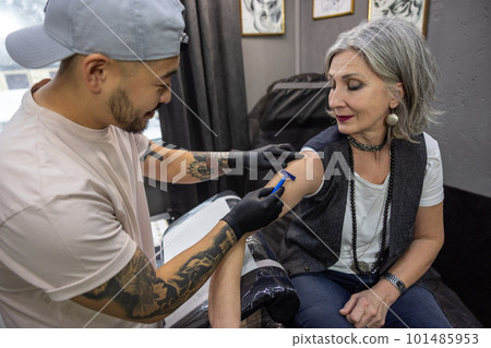 Long-haired woman trying on a skretch for a tattoo Long-haired woman trying on a skretch for a tattoo 101485953